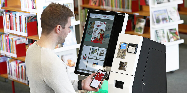 Mann nutzt Smartphone mit digitalem Bibliotheksausweis zur Authentifizierung